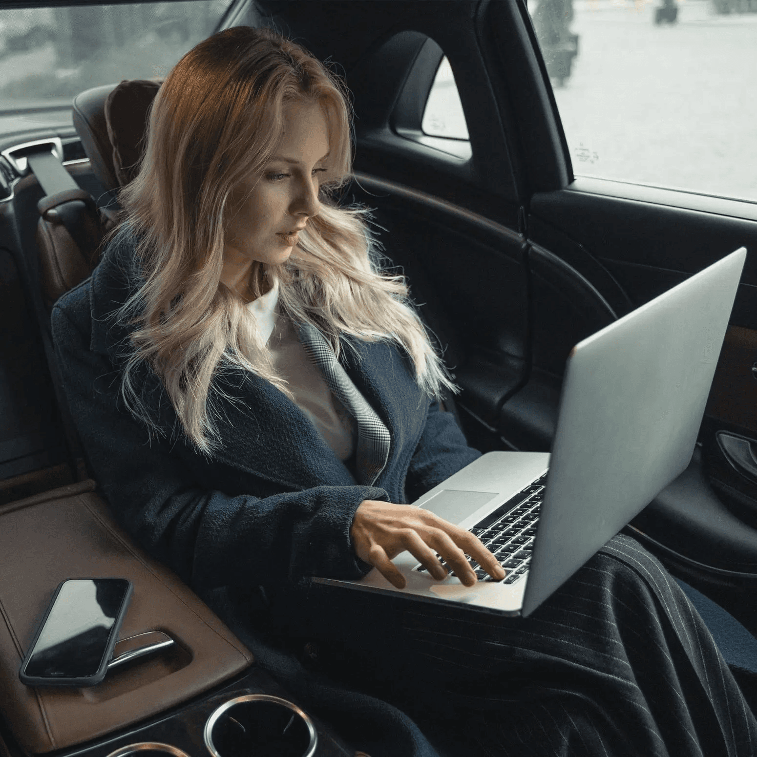 Picture of a Business-woman using her computer in the backseat of the car
