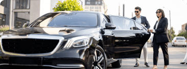 Passengers arriving comfortably at their destination after a city-to-city trip in a chauffeured vehicle.